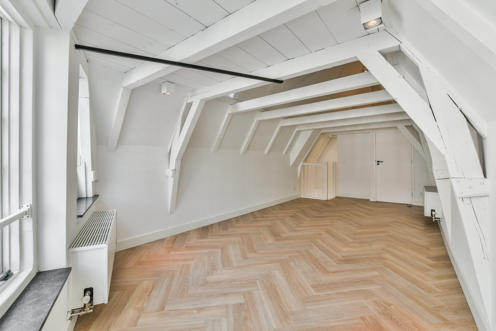 an empty room with wood flooring and white painted walls in the space is very spacious, but it's not too